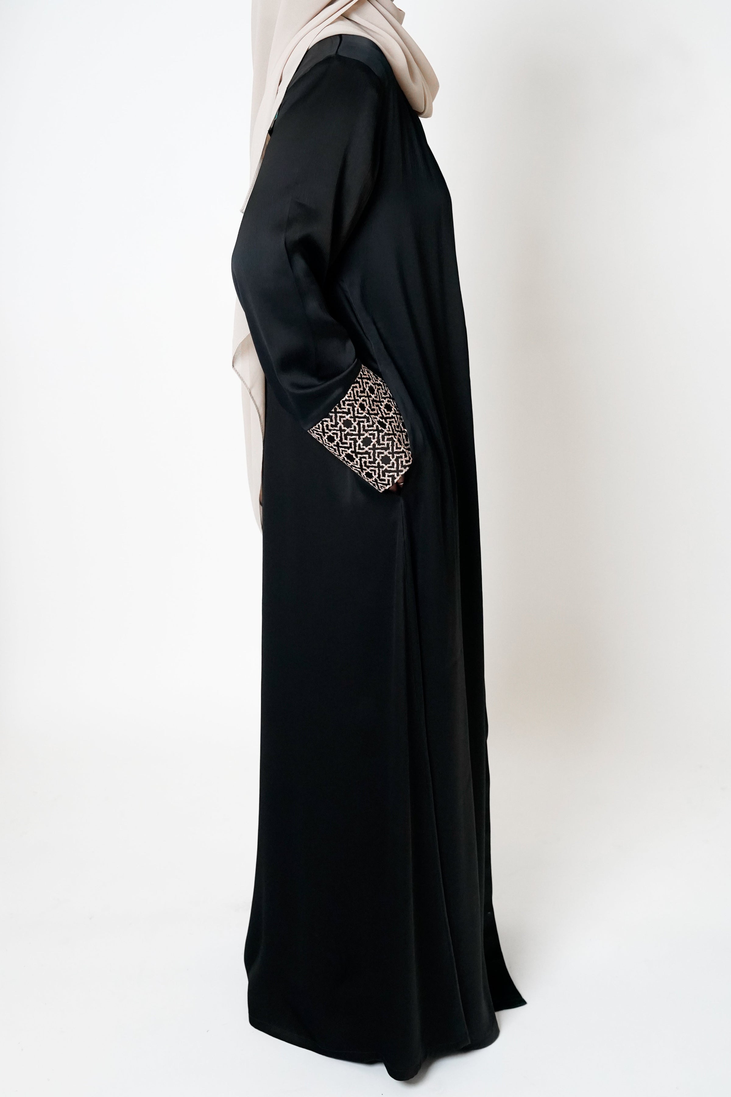 Black crepe open abaya featuring a geometric embroidered print on the cuffs, offering sophistication and elevating modest style with an exclusive design