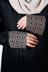 Black crepe open abaya featuring a geometric embroidered print on the cuffs, offering sophistication and elevating modest style with an exclusive design