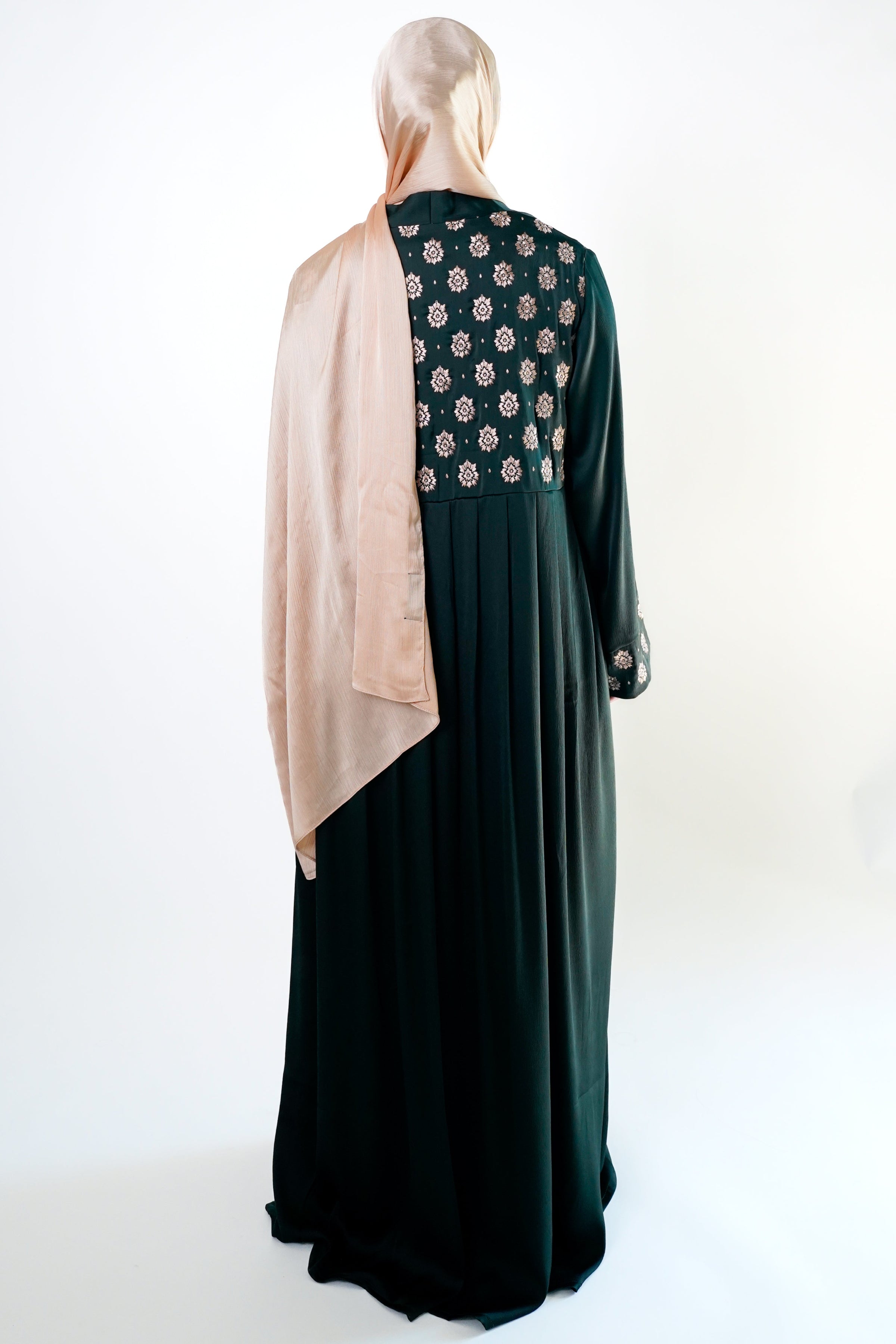 an elegant emerald green kimono with intricate floral embroidery on the back. The kimono has long sleeves.
