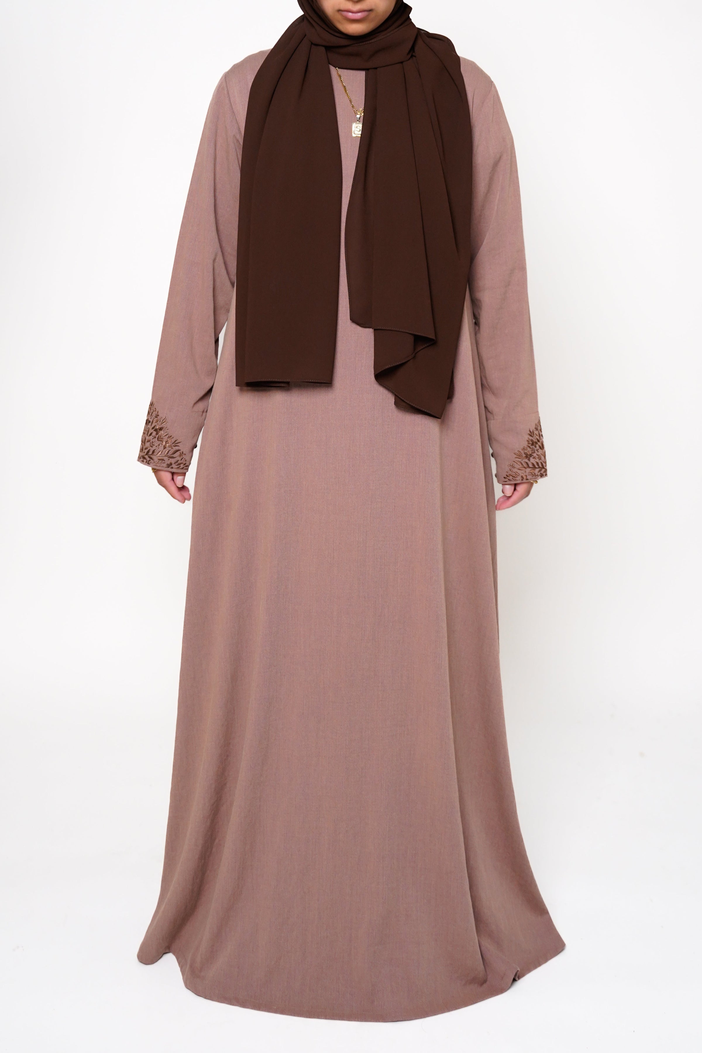 Heather Sand Button Back Embroidered Abaya Back view of a brown abaya with intricate embroidery on the buttons, back, and sleeve ends, offering sophistication and exclusivity. A timeless piece perfect for both dinner parties and masjid visits, combining style and comfort