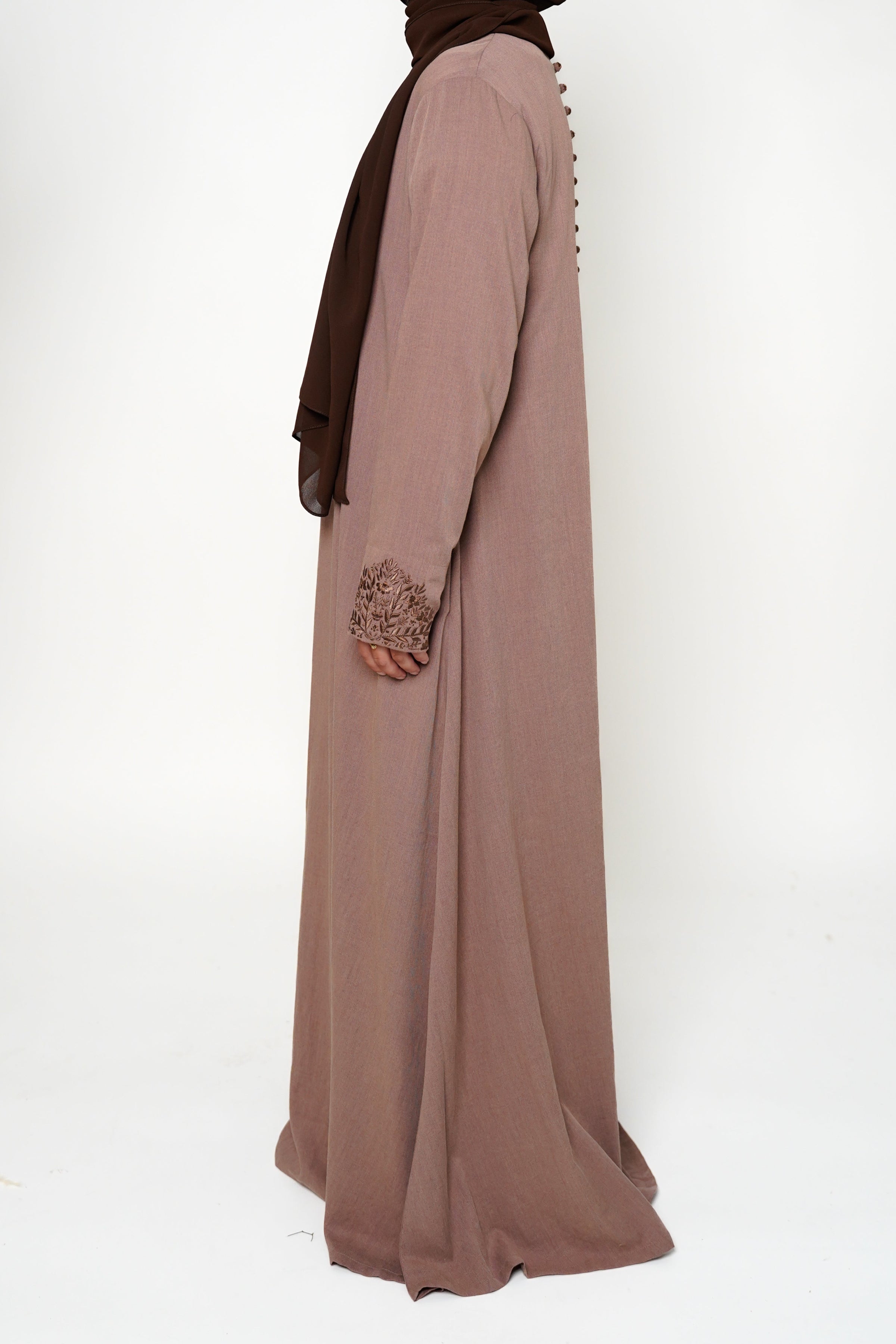 Heather Sand Button Back Embroidered Abaya Back view of a brown abaya with intricate embroidery on the buttons, back, and sleeve ends, offering sophistication and exclusivity. A timeless piece perfect for both dinner parties and masjid visits, combining style and comfort