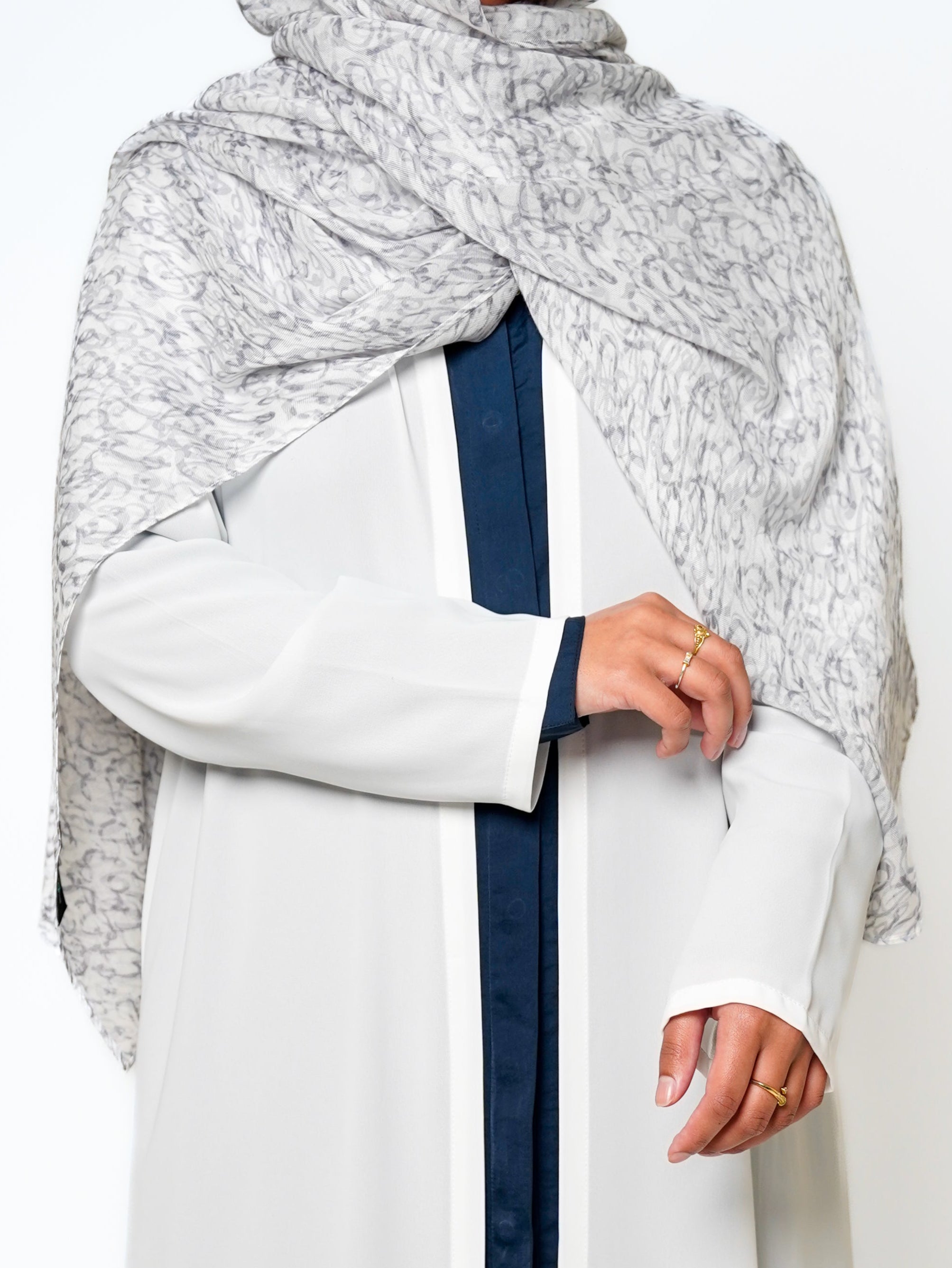 Sacred Script Bamboo Modal Hijab in a soft white color featuring a delicate abstract pattern in shades of gray, offering a subtle and elegant design.