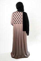 A woman wearing a Stone Embroidered Back Kimono with black floral embroidery on the upper back, with a black hijab