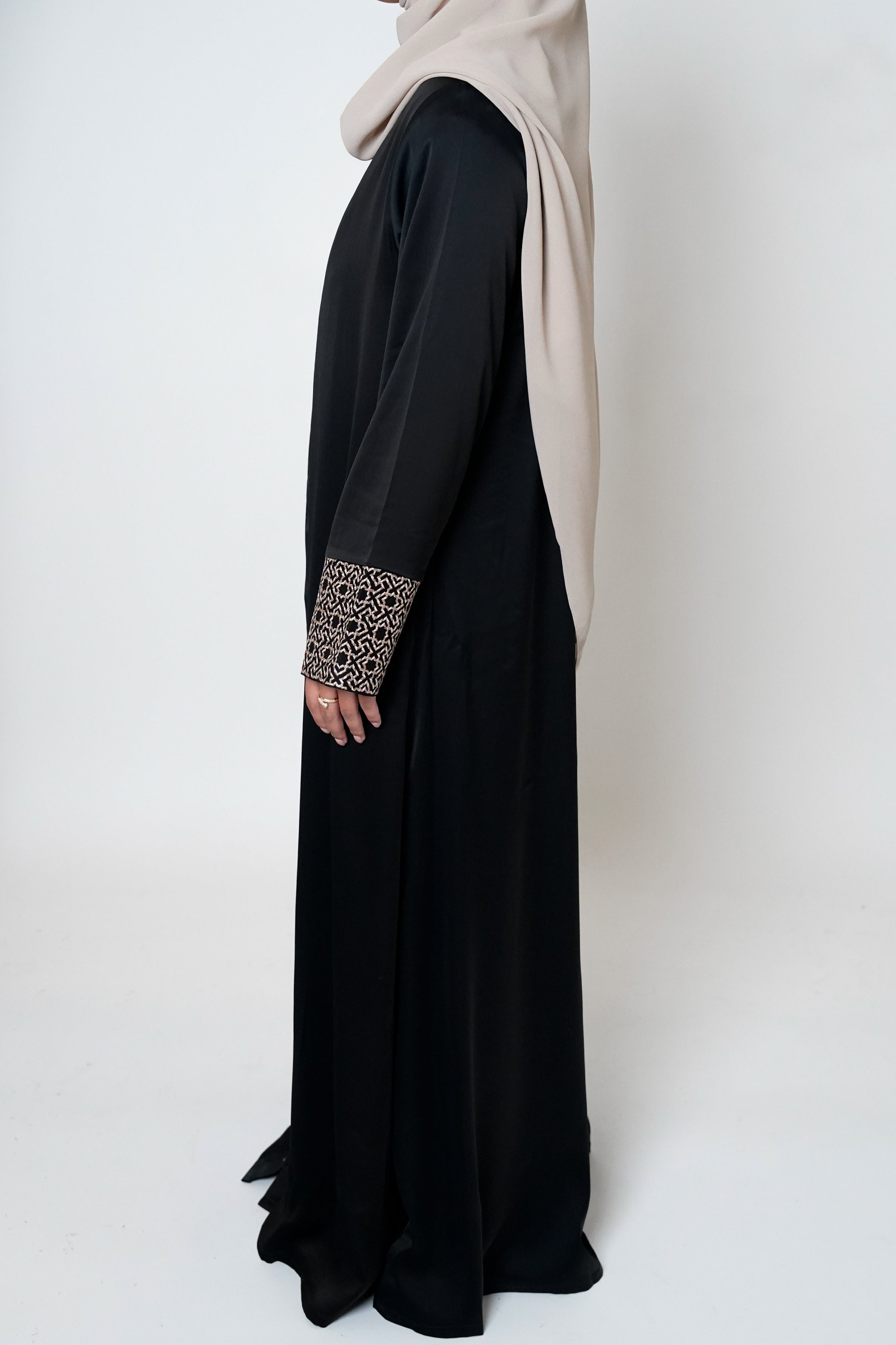 Black crepe open abaya featuring a geometric embroidered print on the cuffs, offering sophistication and elevating modest style with an exclusive design