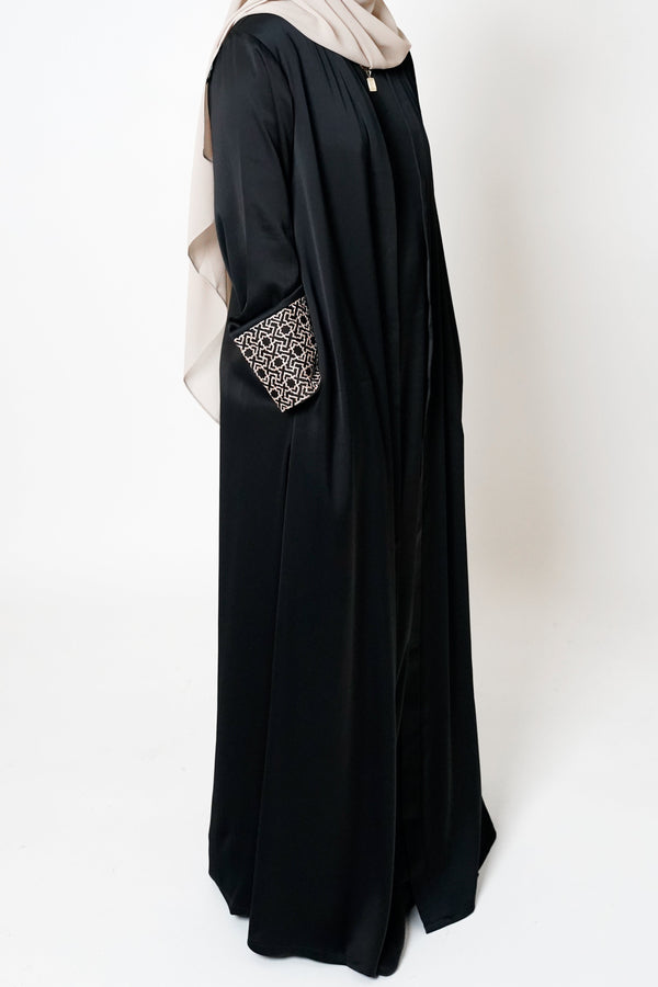 
Black Geo Embroidered Cuff Open Abaya featuring a geometric embroidered print on the cuffs, offering sophistication and elevating modest style with an exclusive design