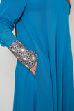 Side view of the Luxury Caspian Blue Embroidered Cuff Abaya, highlighting the intricate cuff embroidery in blue and gold with side pockets. The abaya is made from soft fabric with a flowing design, offering both sophistication and comfort.