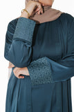Close-up of the slate blue open abaya, highlighting the embroidered geometric print on the cuffs, adding sophistication and elevating modest style with an exclusive design.