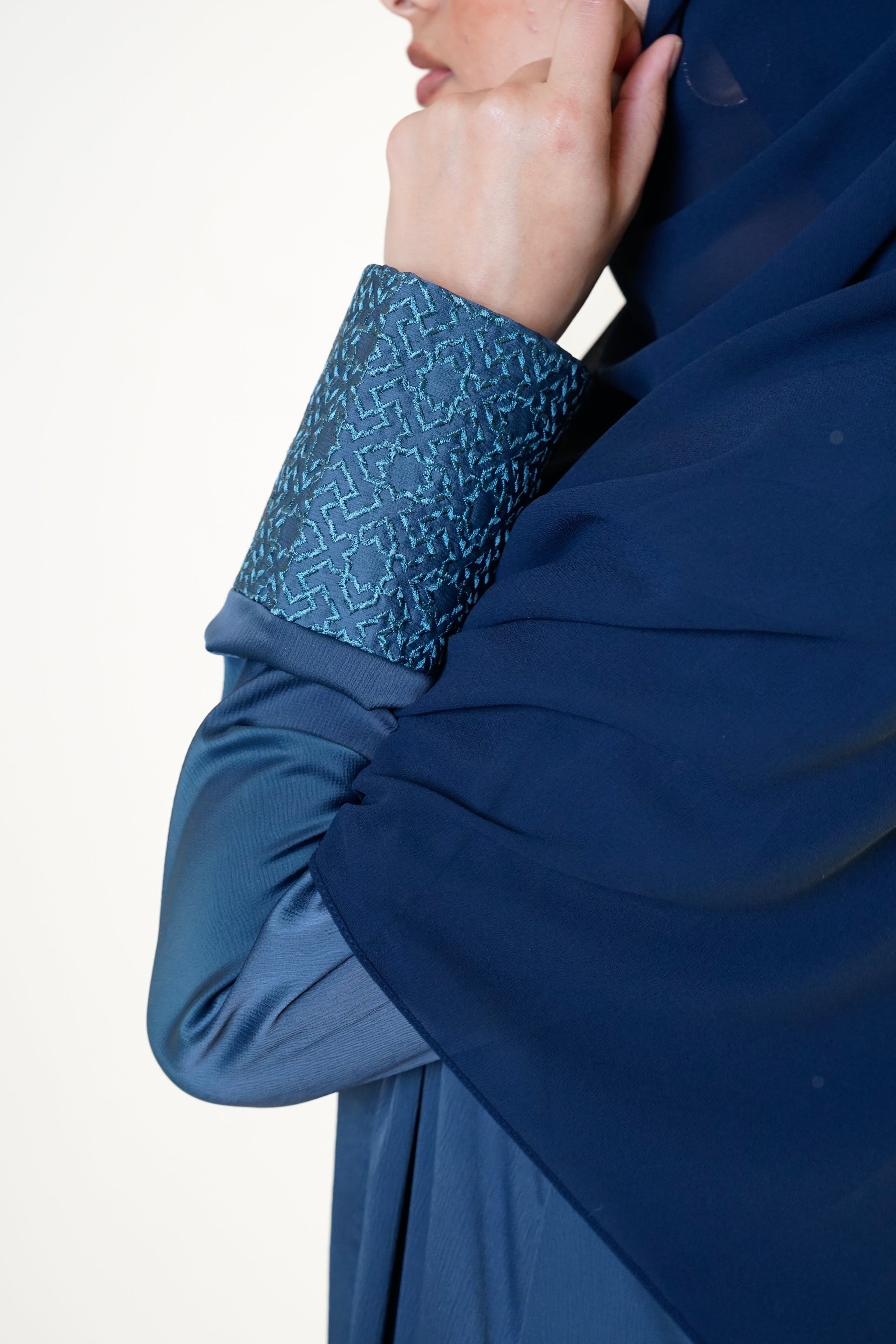 Slate blue open abaya with geometric embroidered cuffs, offering a sophisticated and exclusive design that elevates modest style