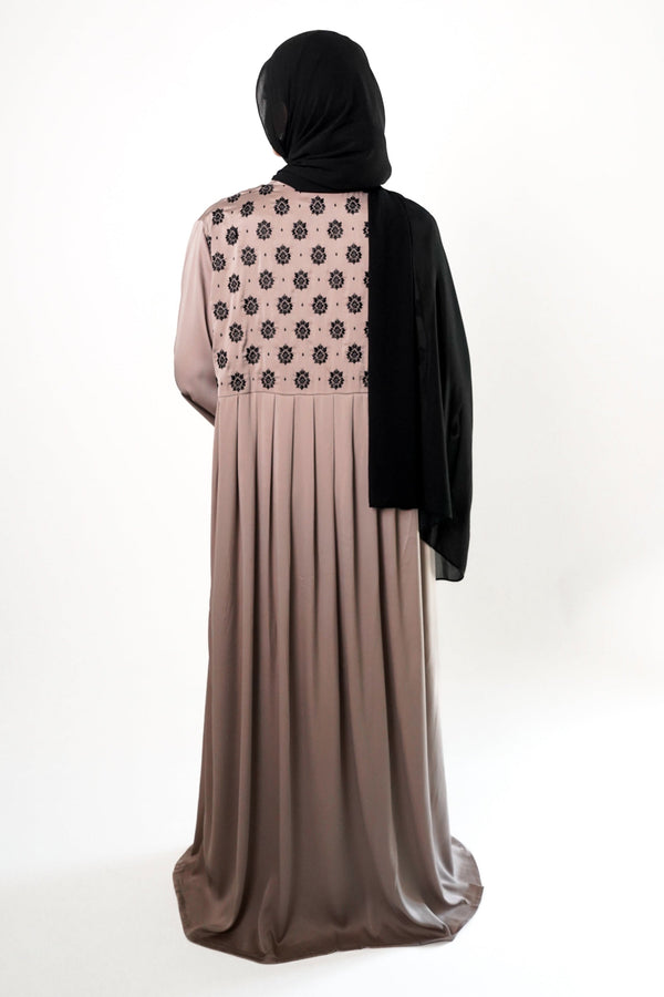 A woman wearing a Stone Embroidered Back Kimono with black floral embroidery on the upper back, with a black hijab